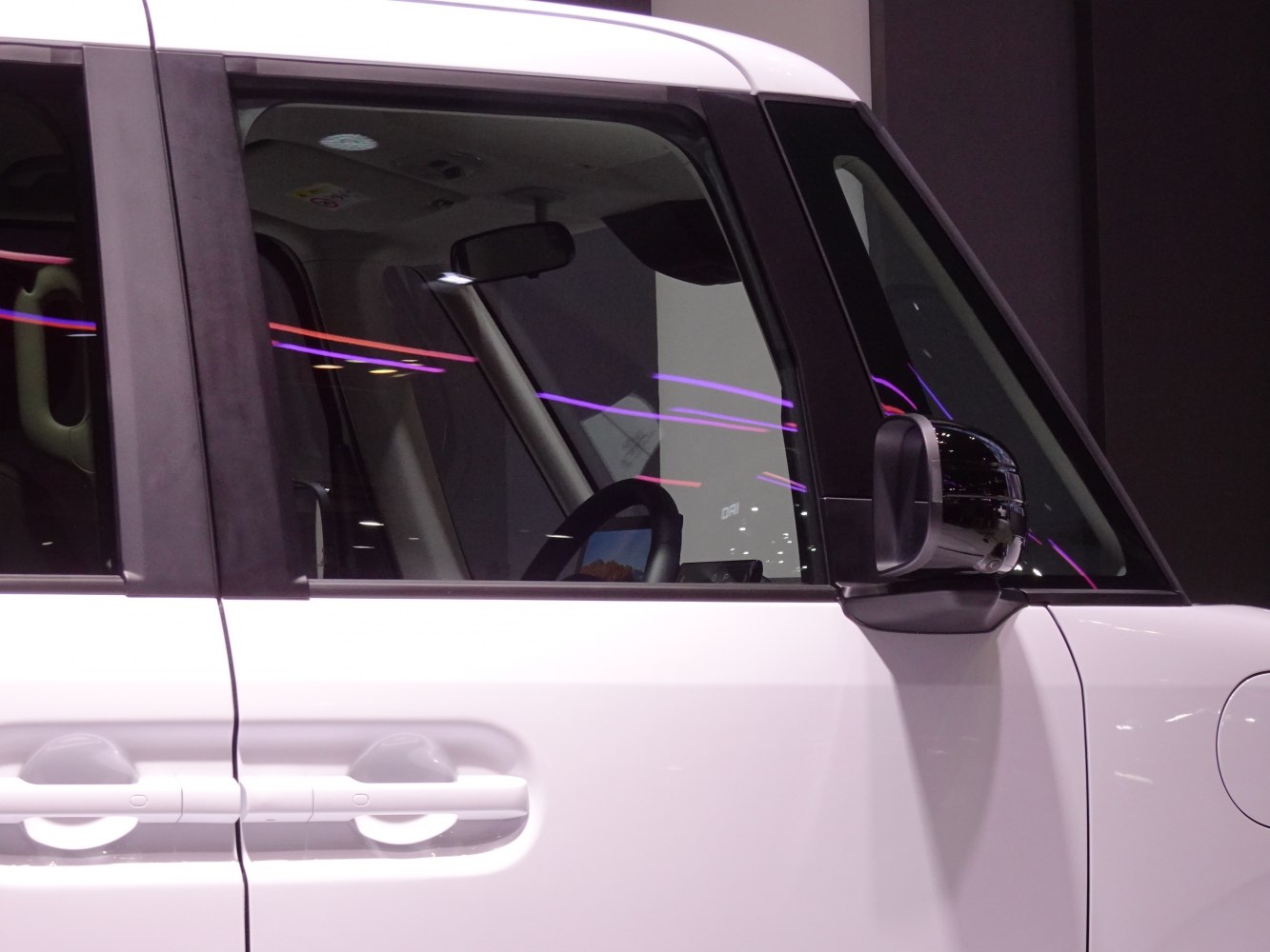 Close-up of car side door handle and mirror with window reflection