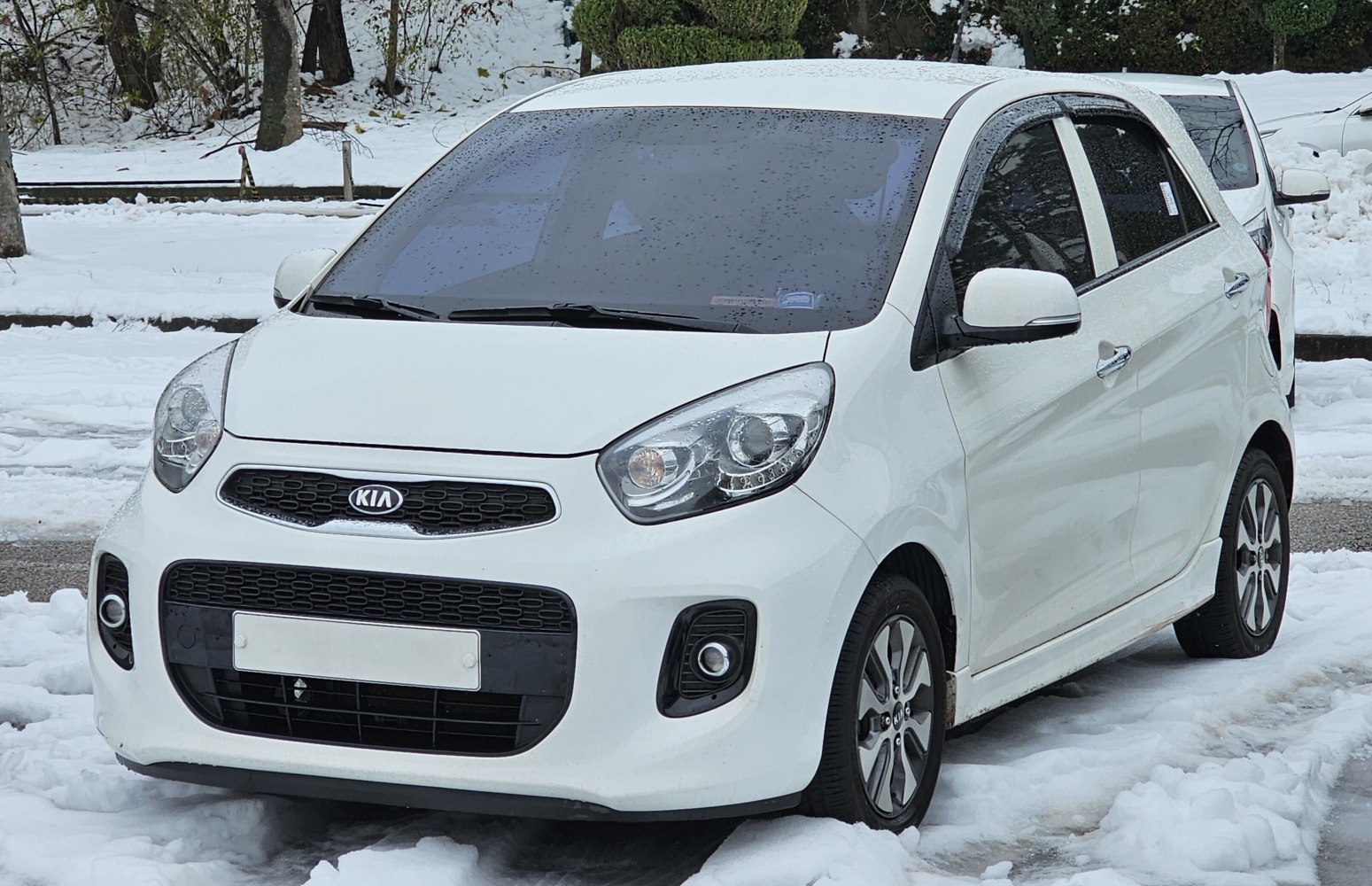 Front view of compact white hatchback with modern headlights and grille