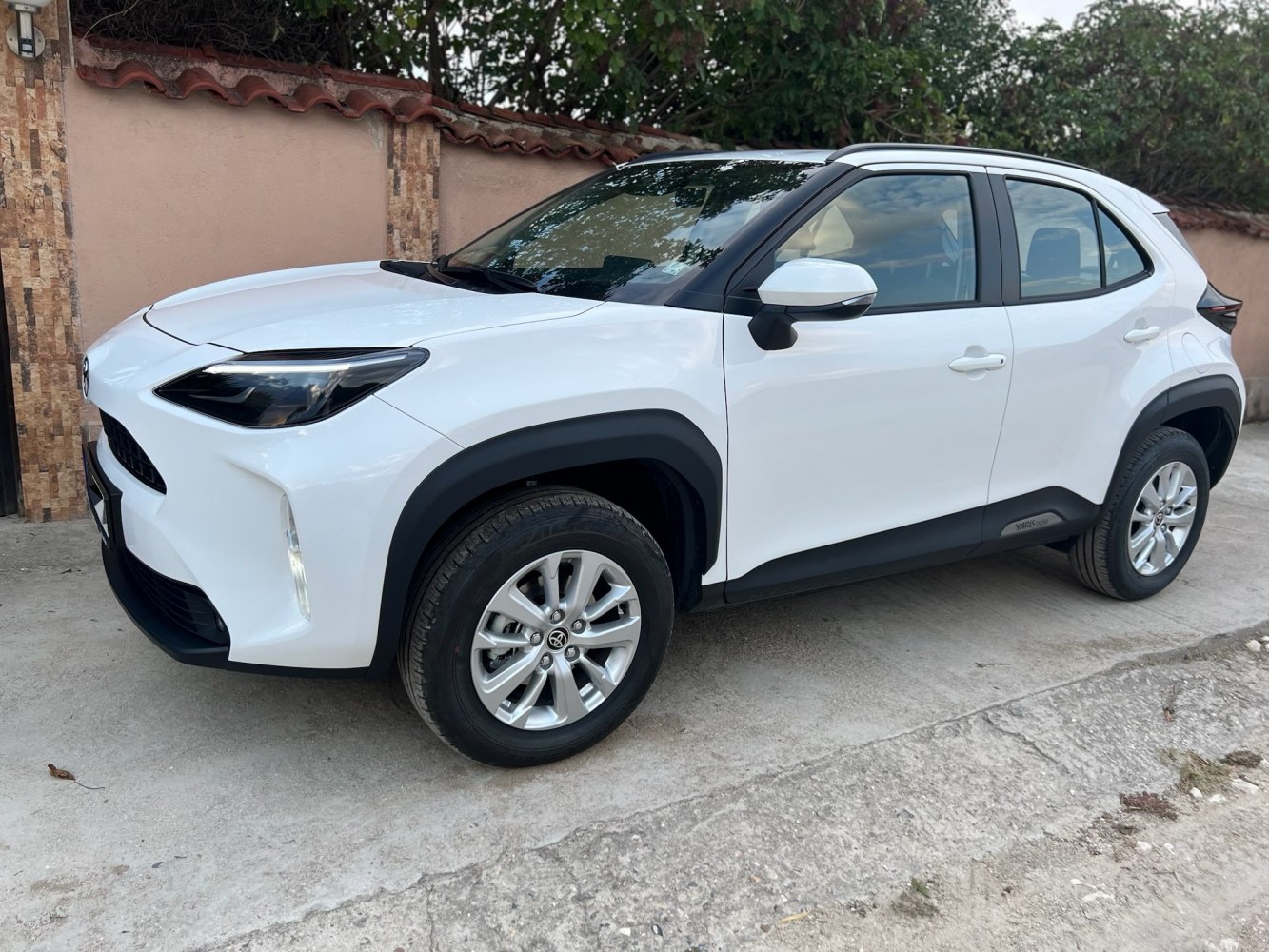 White compact SUV side front view with black trims and alloy wheels