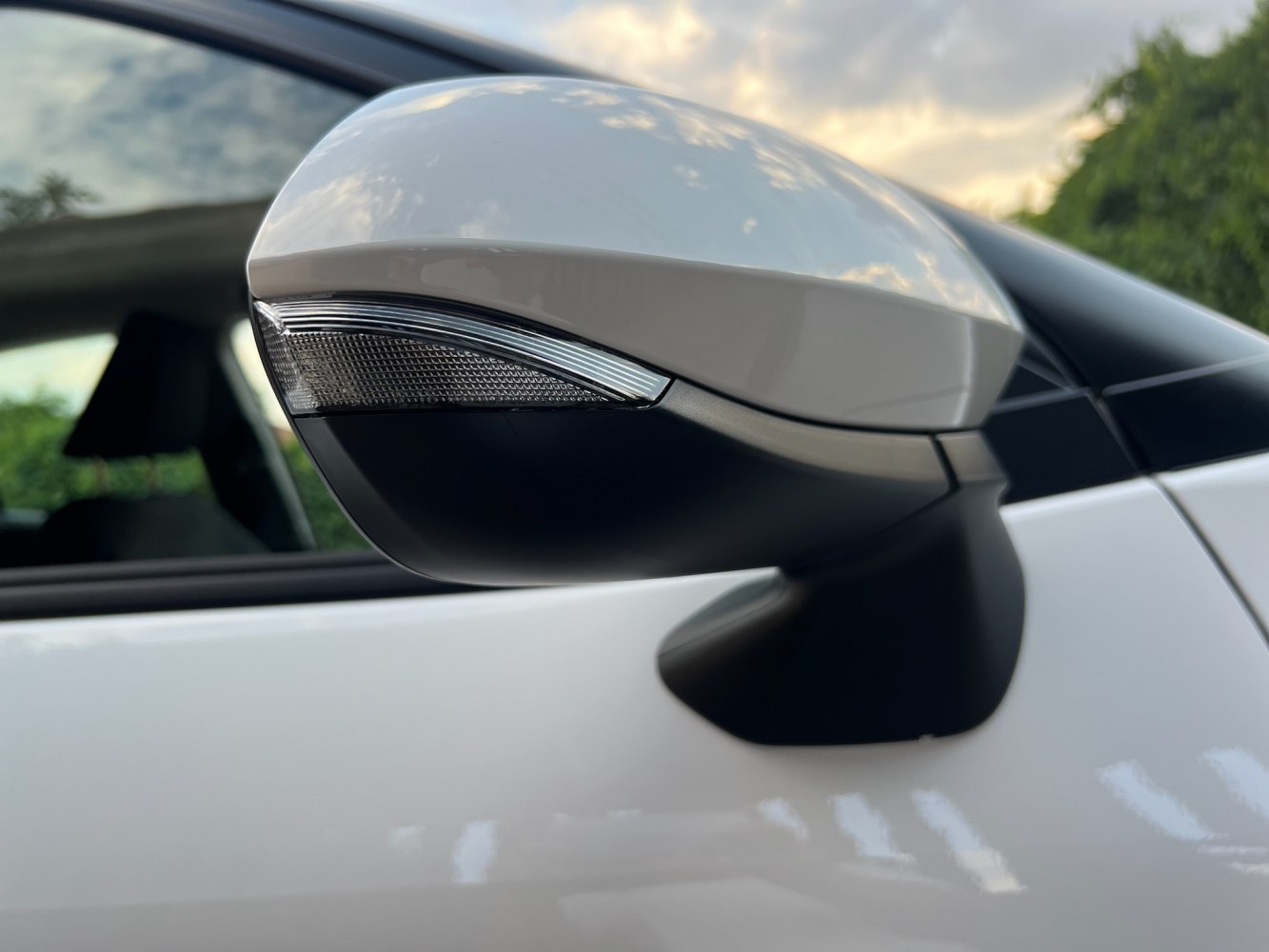 Side mirror with integrated indicator on white car door