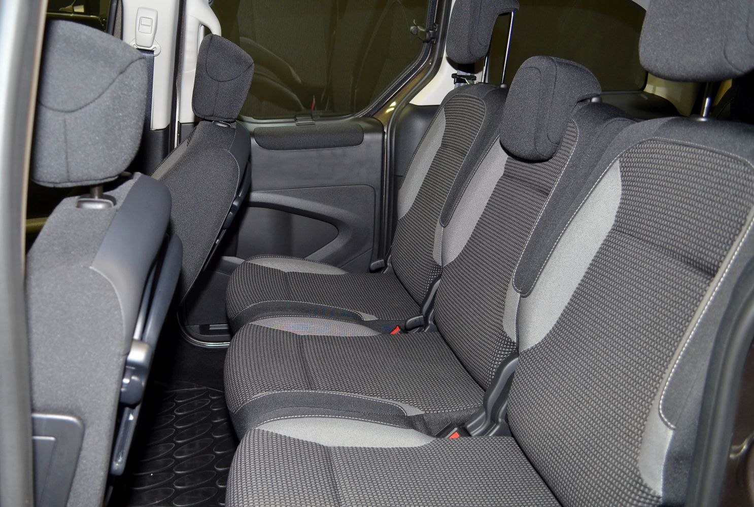 Rear fabric seats with adjustable headrests in a multi-passenger layout