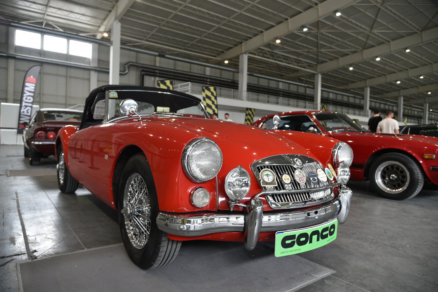 Bright red convertible with chrome wire wheels and twin chrome headlights