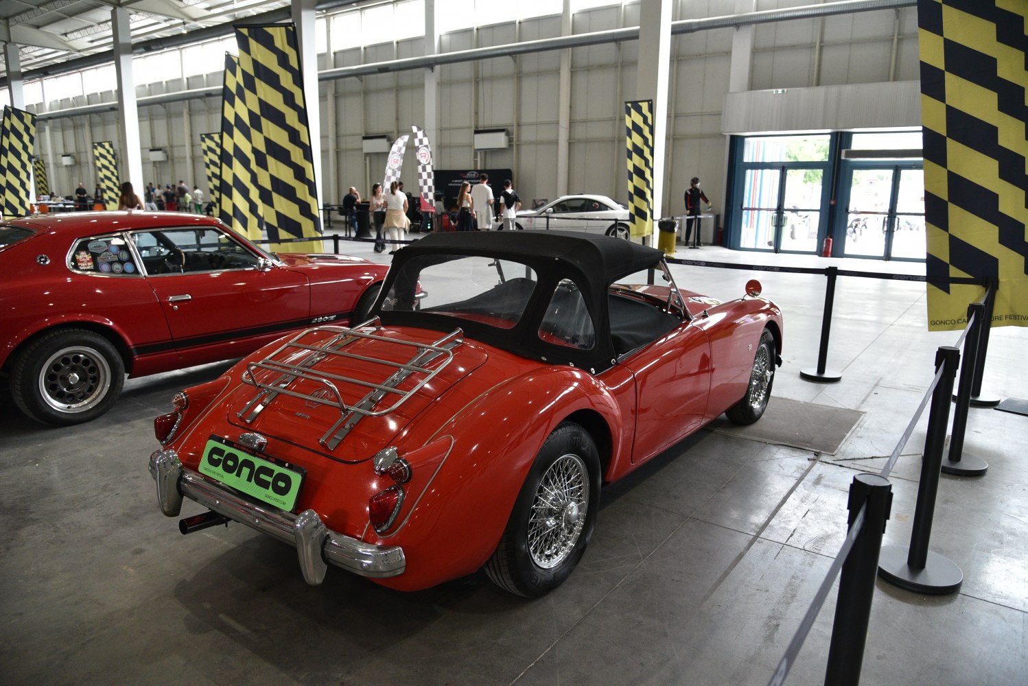 Red vintage convertible with black soft top and chrome rear luggage rack