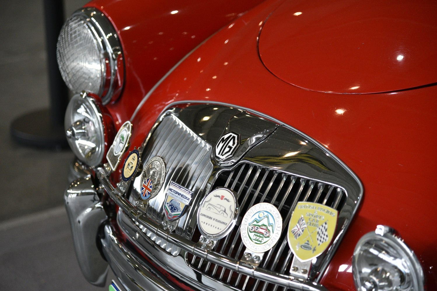 Close-up of vintage front grille with multiple badges and headlights