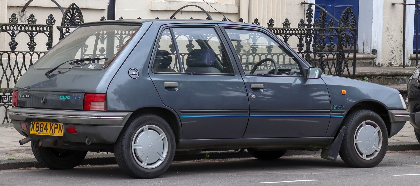 Side profile of a five-door hatchback with distinctive hubcaps and classic design