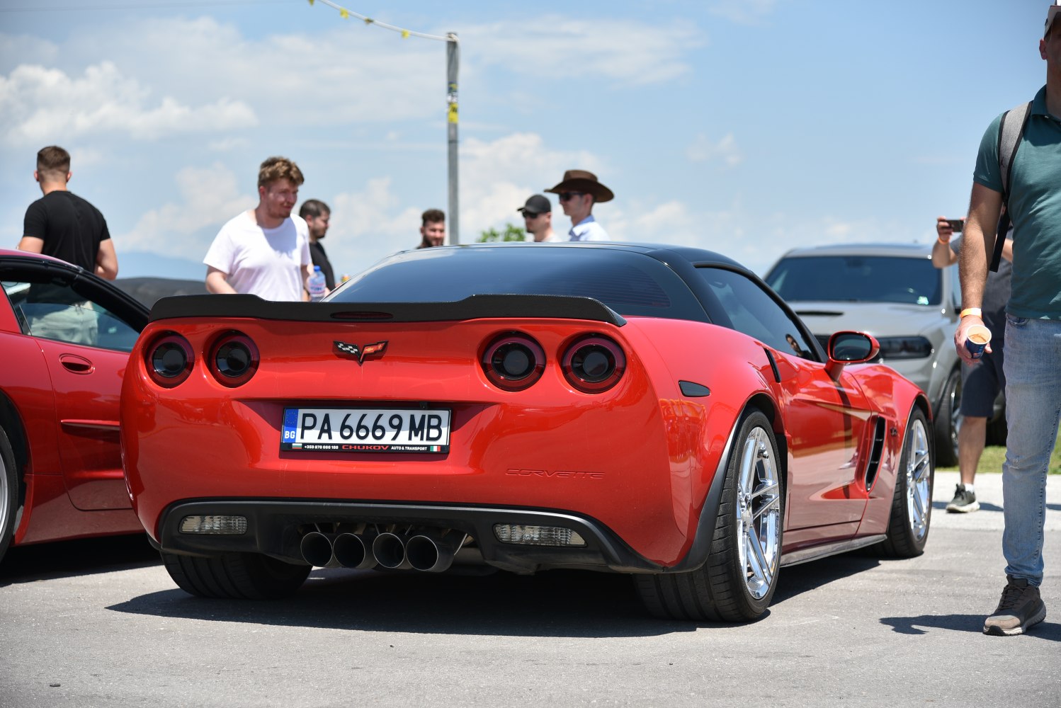 Rear view of a red sports coupe with quad exhausts and round taillights.