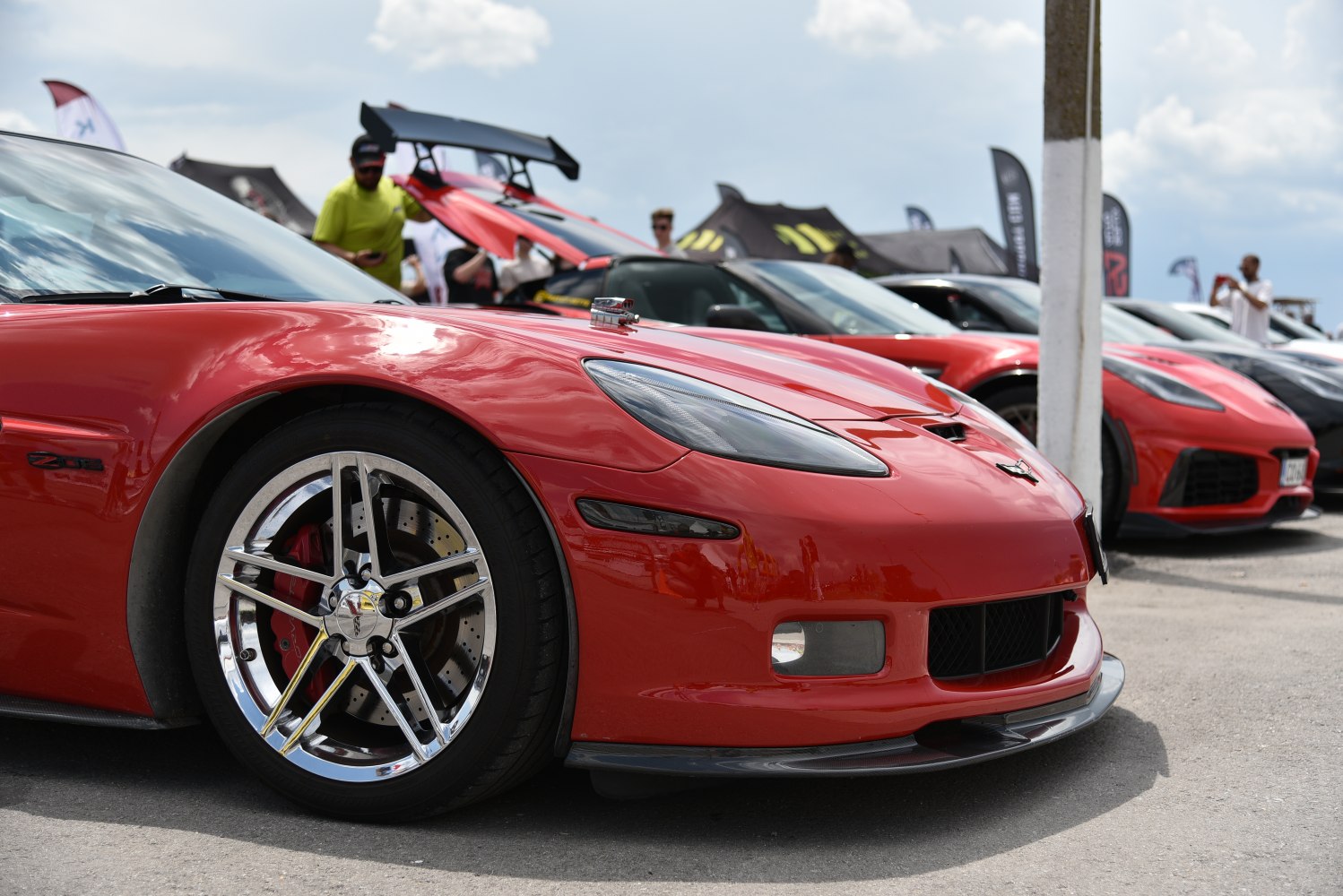 Close-up of red sports car front with chrome alloy wheel and headlight