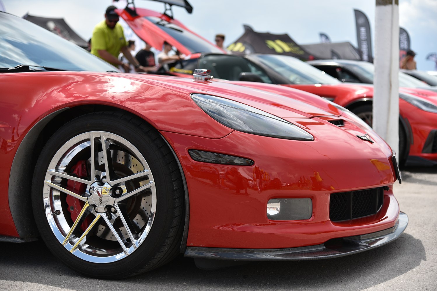 Front wheel and headlight detail of a red sports coupe