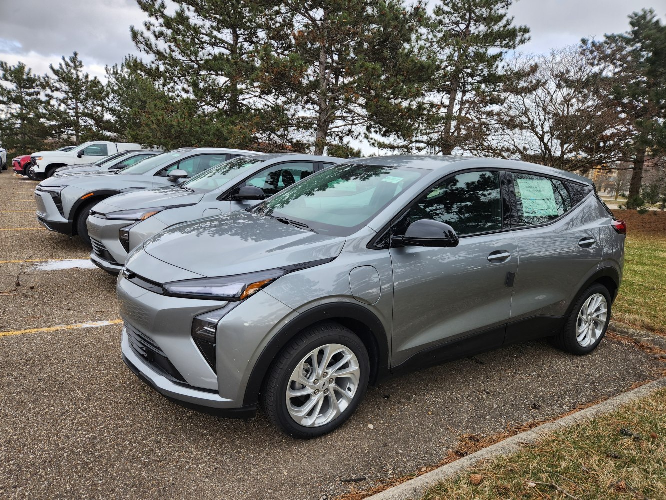 Grey electric vehicle with front and side view, charging port, alloy wheels