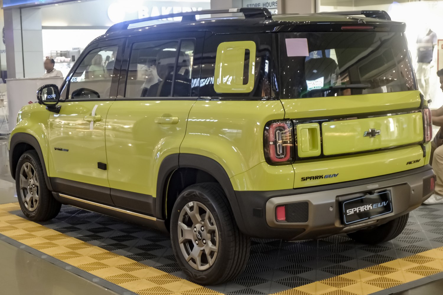 Two-tone yellow and black rear side view with distinctive rear lights and bumper