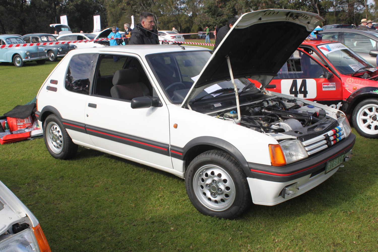 White 3-door hatchback with open hood revealing engine bay