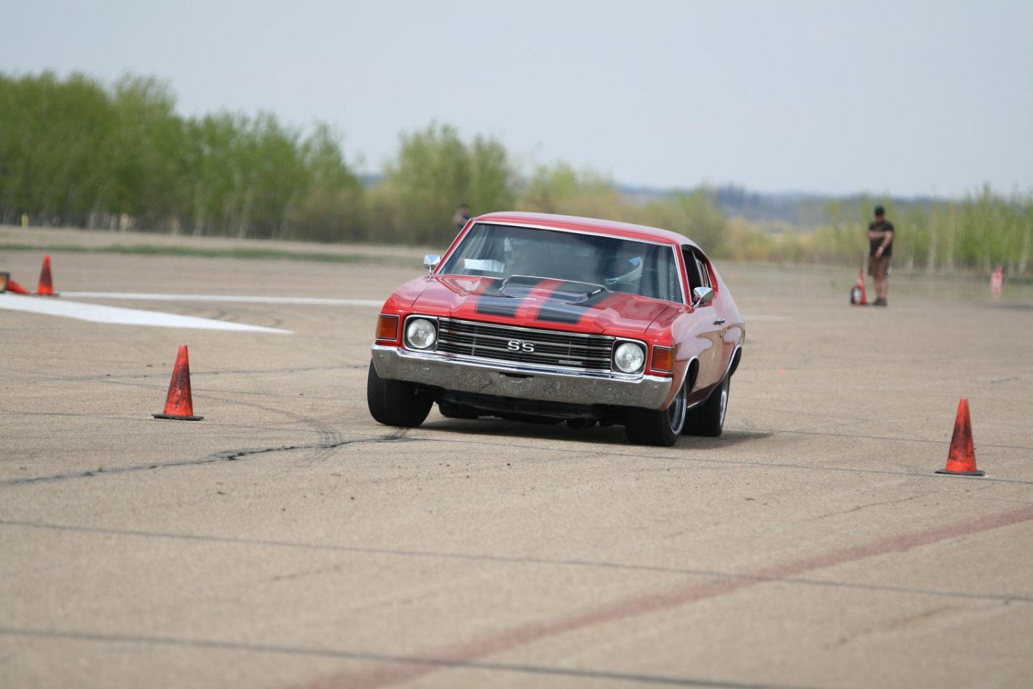 Front view of classic muscle car with hood scoop and racing stripes.