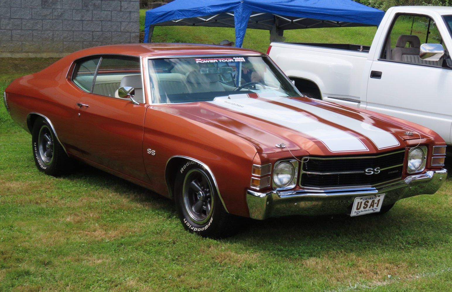 Muscle car with dual racing stripes, SS badge, and classic hood pins