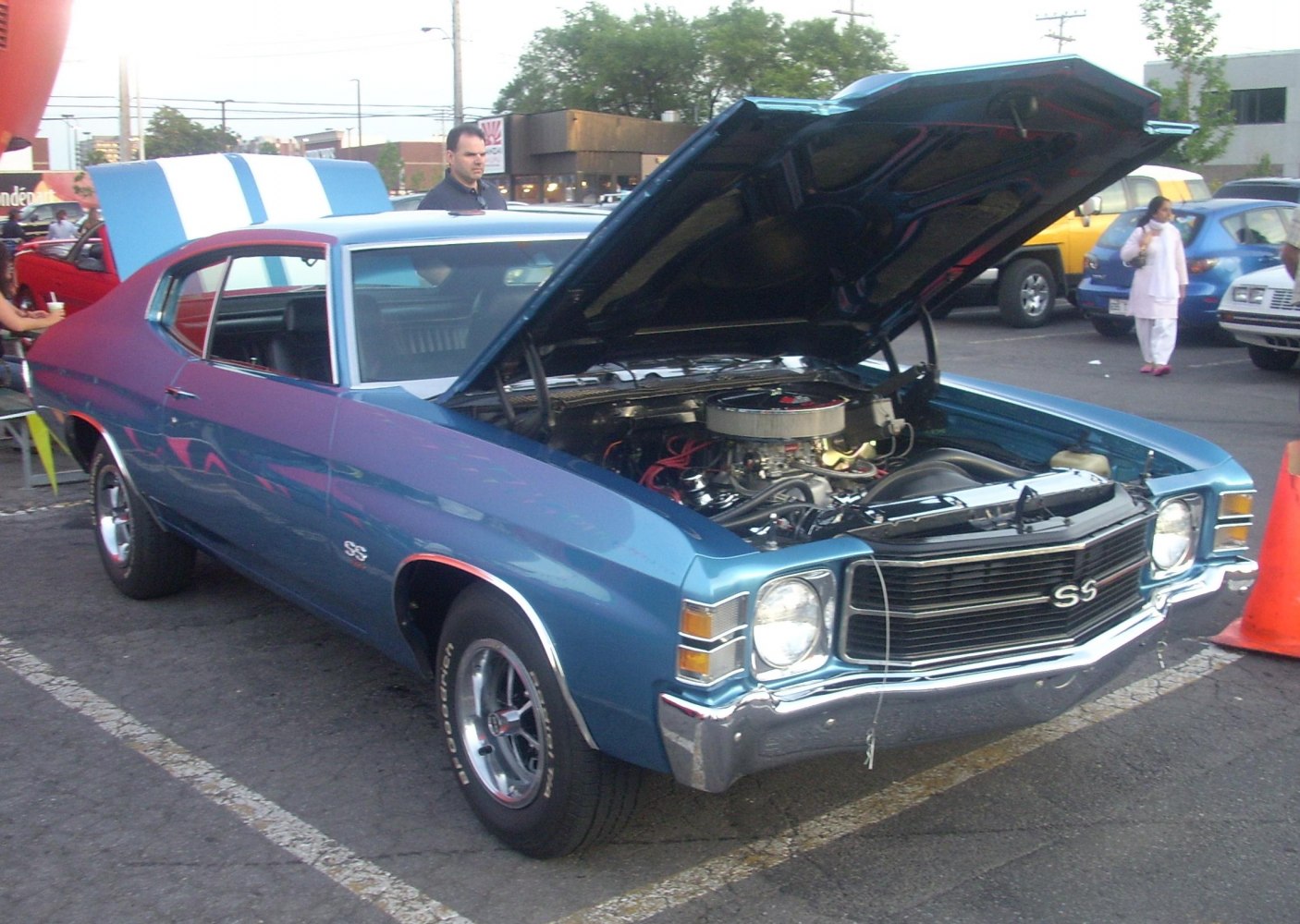 Front angle view of a muscle car with open hood and visible engine bay