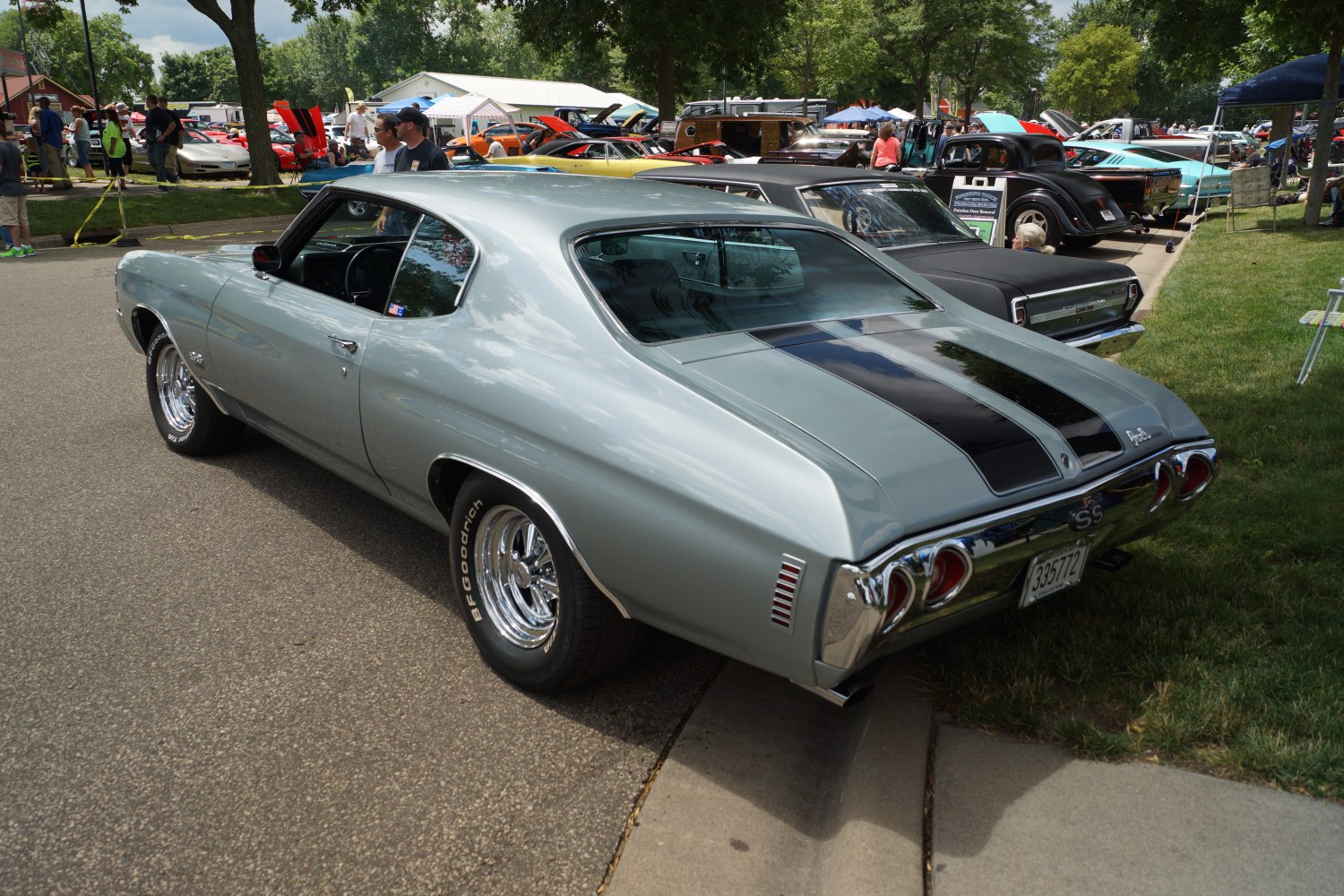 Rear and side angle of a classic muscle car with dual black racing stripes.