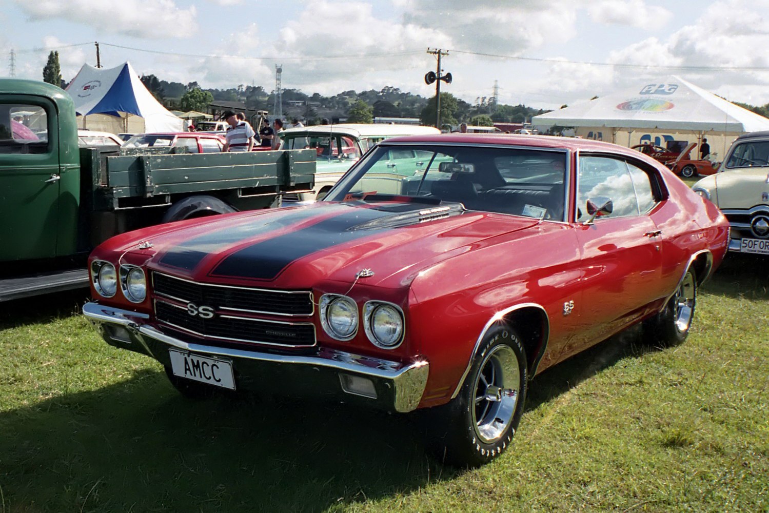 Front angle of classic muscle car with hood scoop and racing stripes