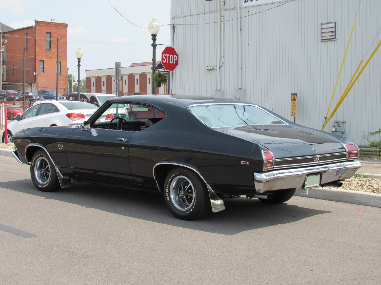 Black muscle coupe rear side view with chrome bumper and fastback roofline