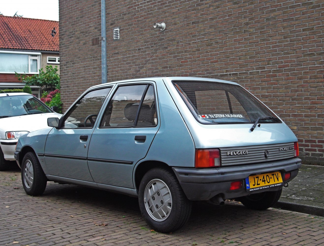Rear side view of a classic compact hatchback with distinctive taillights and rear hatch window.