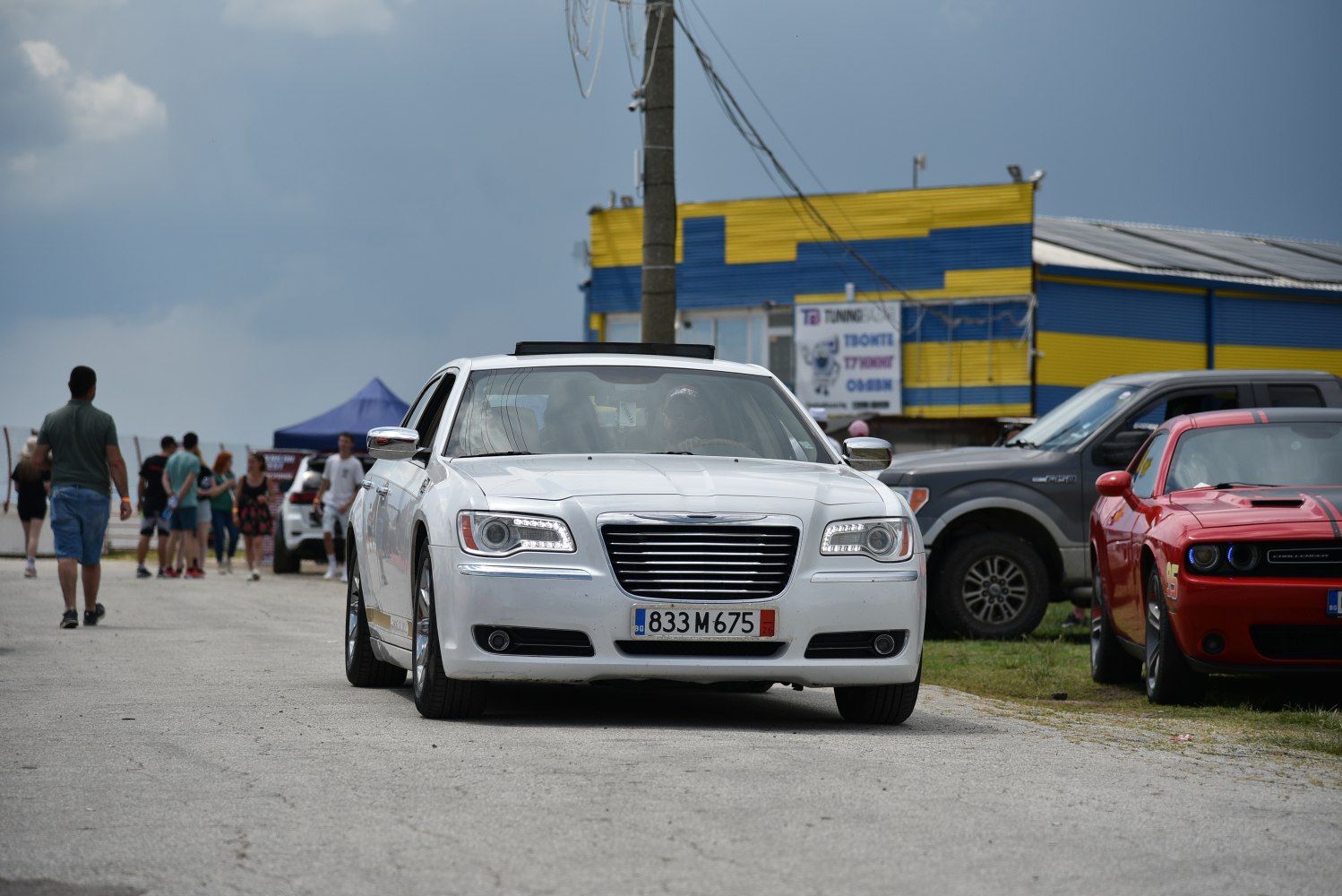 Front view of a white sedan with LED daytime running lights and chrome grille