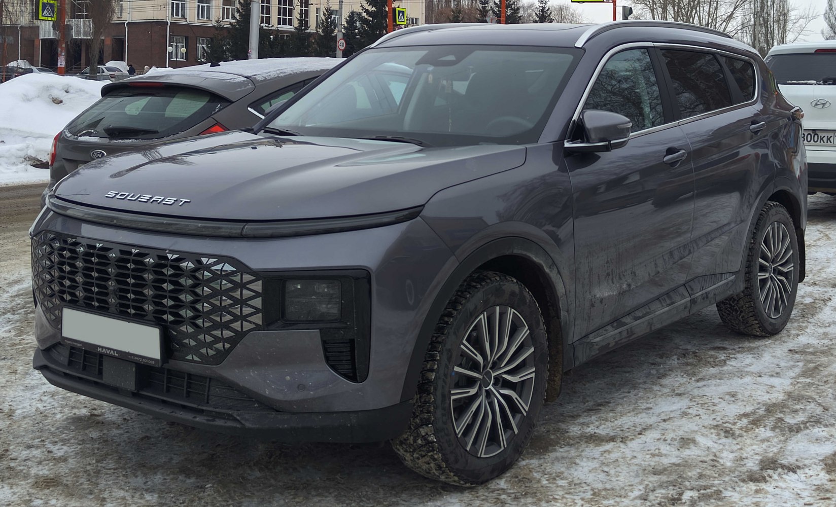 Front-side view of compact SUV with large patterned grille and alloy wheels