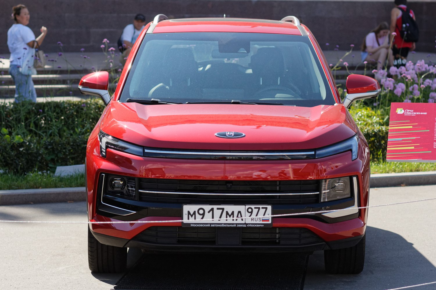 Front view of a red SUV with sleek headlights and modern grille