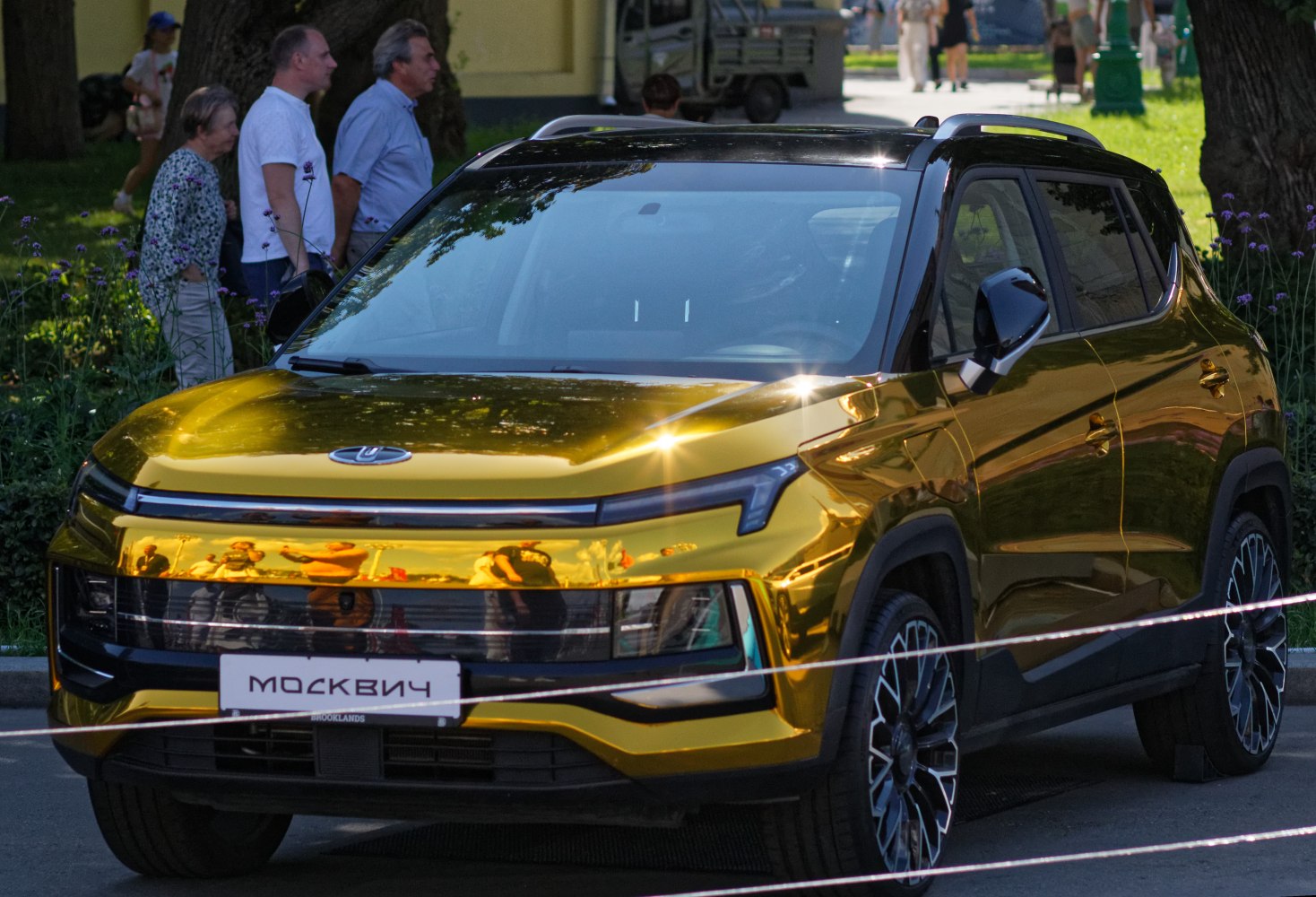 Modern electrified SUV with gold reflective body and black roof.