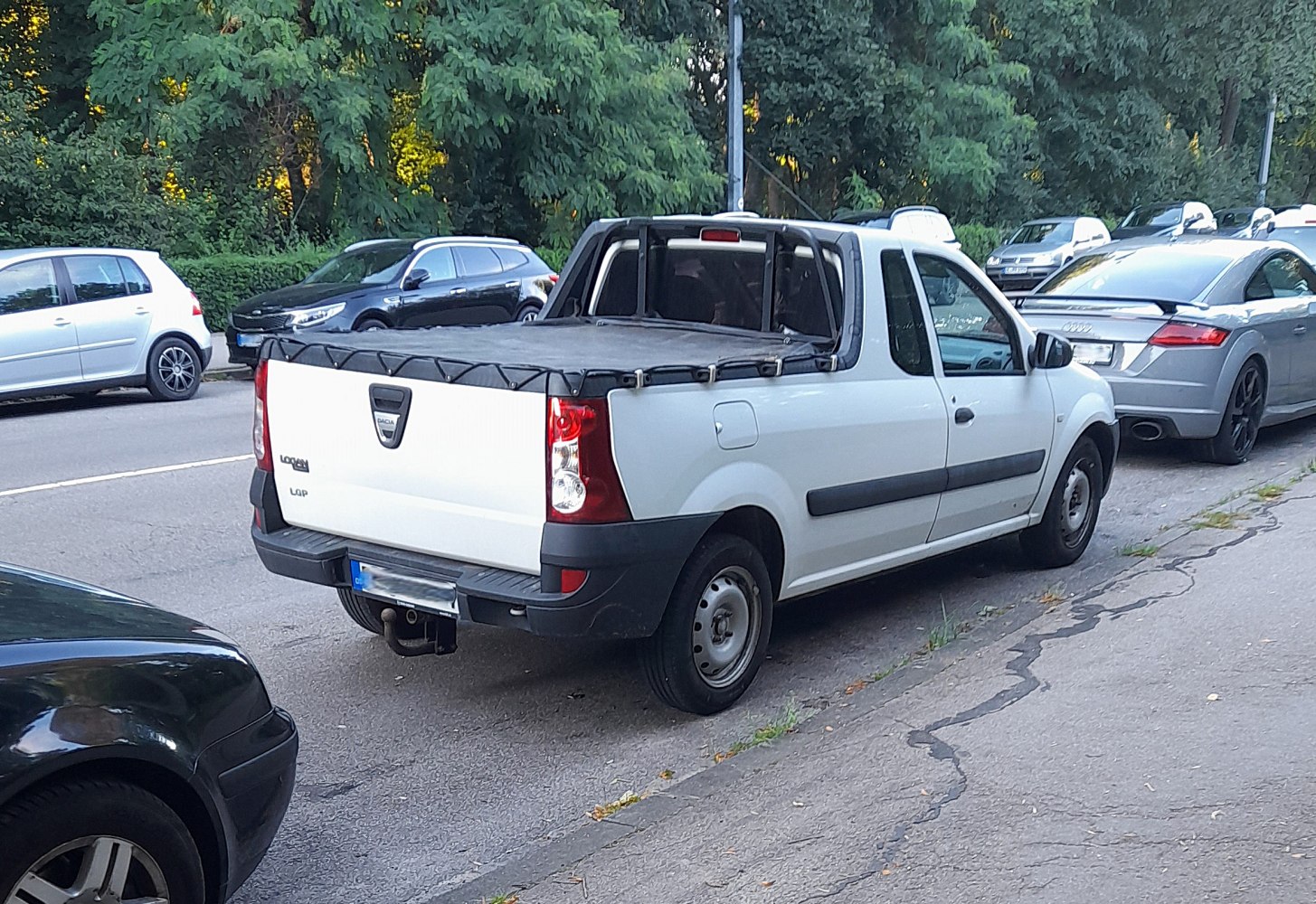 Rear-side view of a small pickup truck with a covered cargo bed.