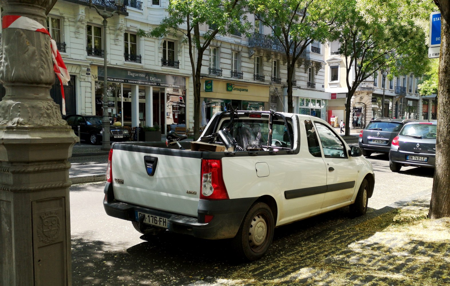 Rear view of a white pick-up truck with cargo bed on city street