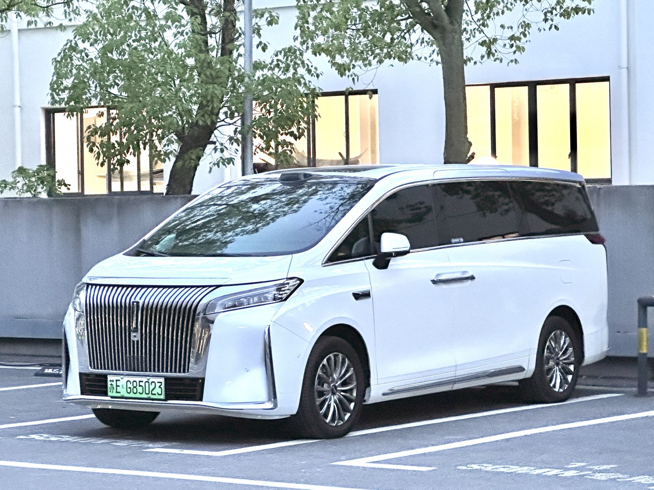 Luxury minivan with bold vertical grille and panoramic windshield