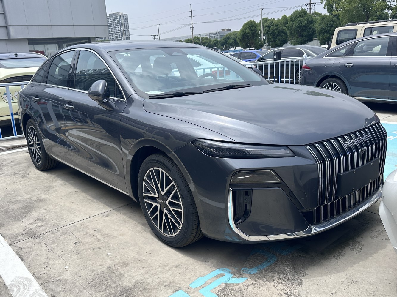 Front and side view of sedan with large vertical grille and unique alloy wheels