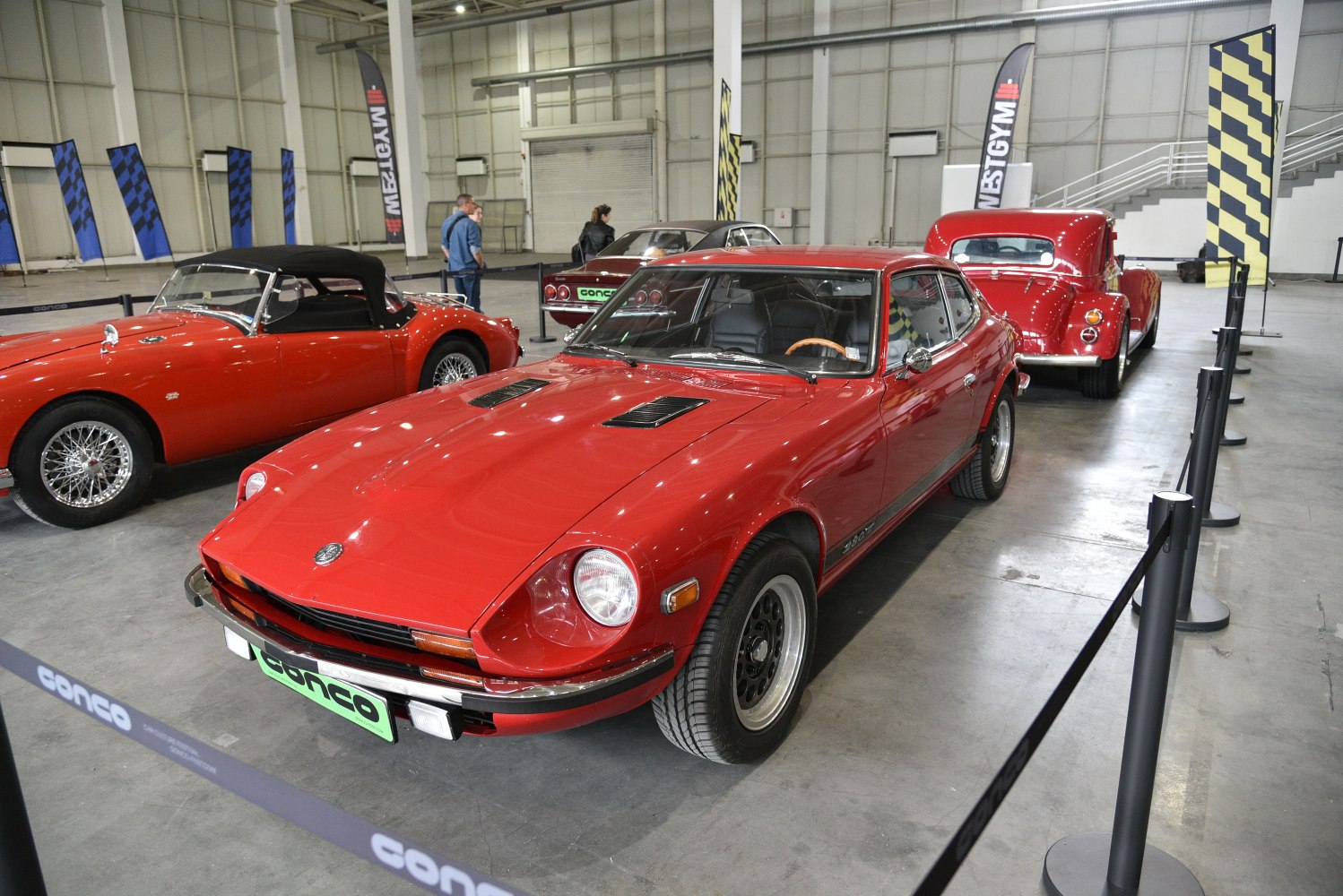 Red vintage sports coupe with hood vents and black wheels