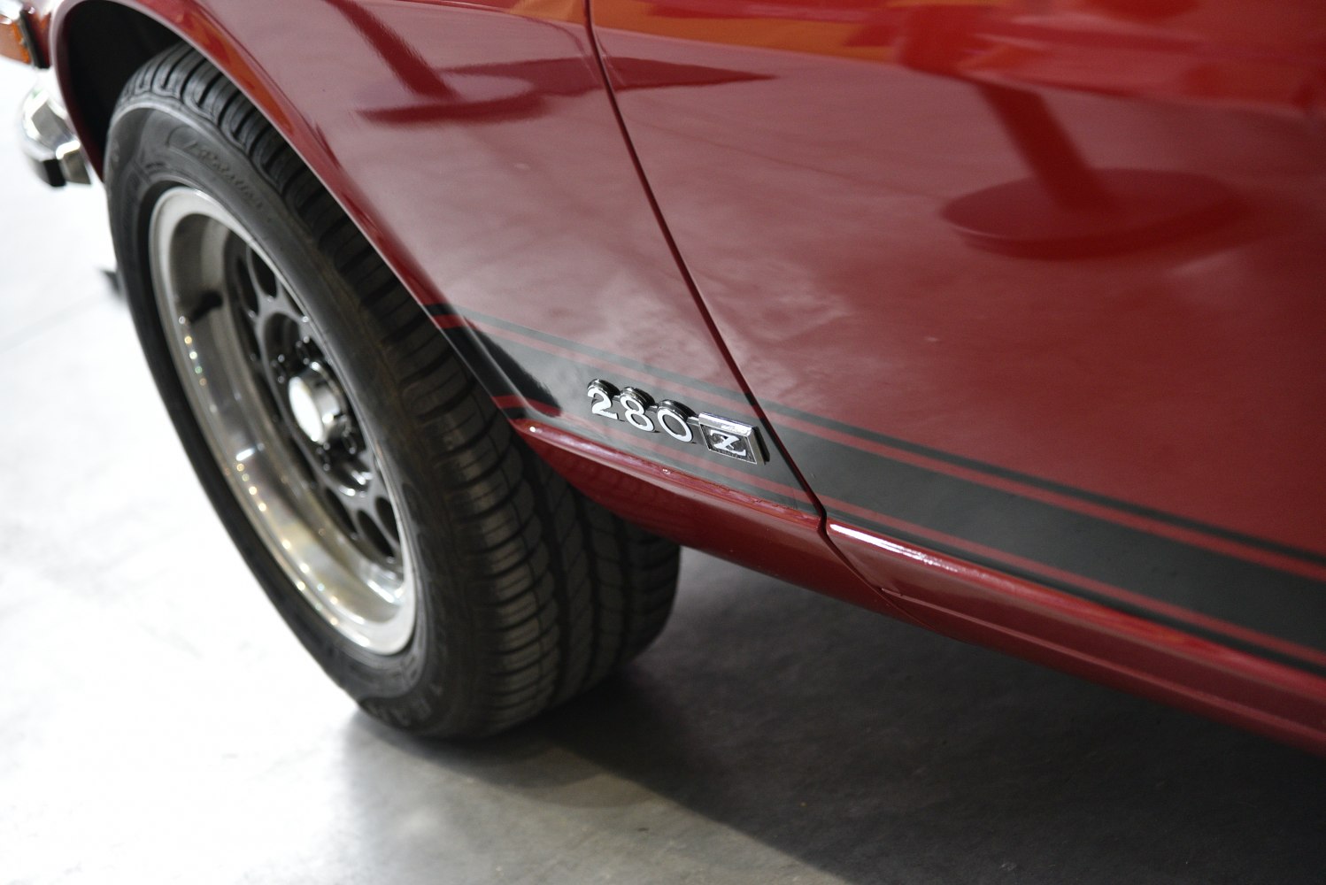 Close-up of side emblem and wheel on red vintage sports car