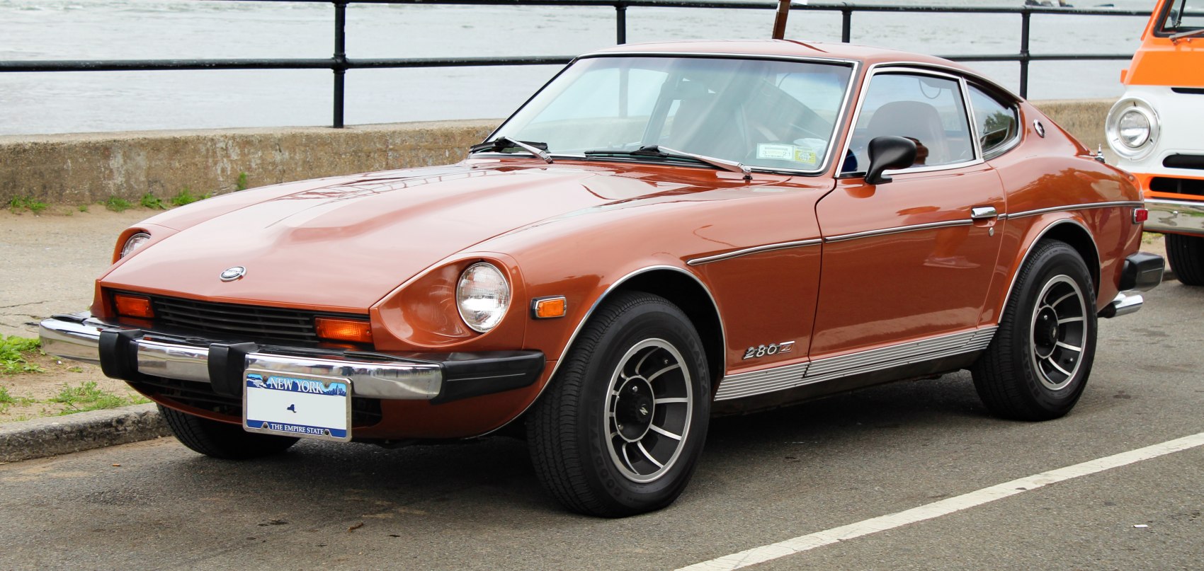 Front-side view of vintage sports coupe with round headlights and black wheels