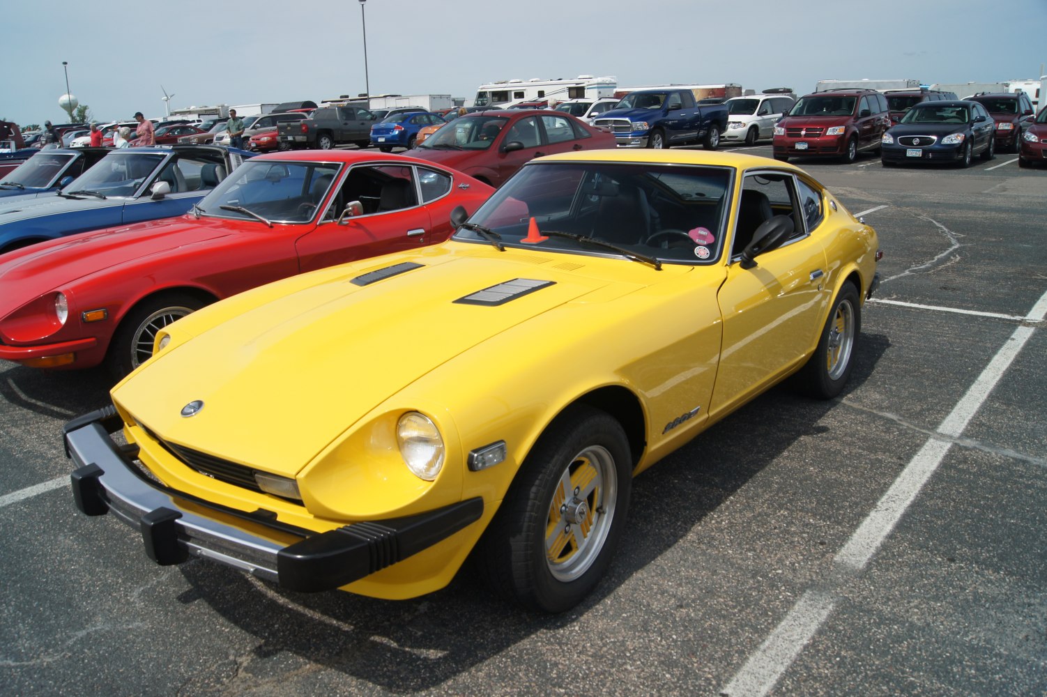 Yellow vintage sports coupe with hood vents and black bumper