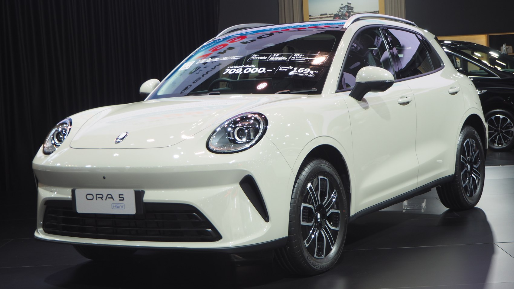 Front-side view with round LED headlights and multi-spoke alloy wheels