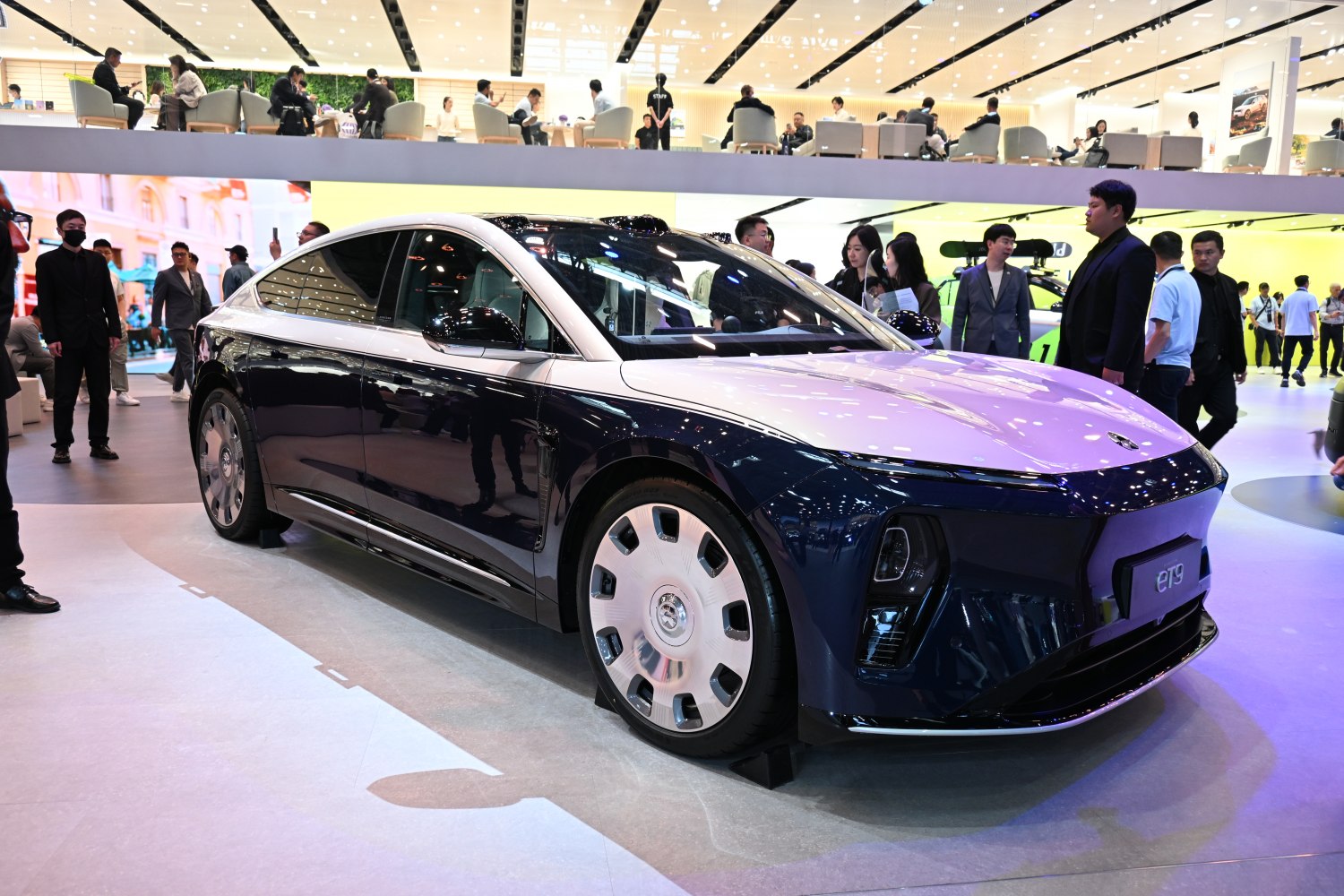 Aerodynamic electric sedan with distinct large multi-spoke wheels.