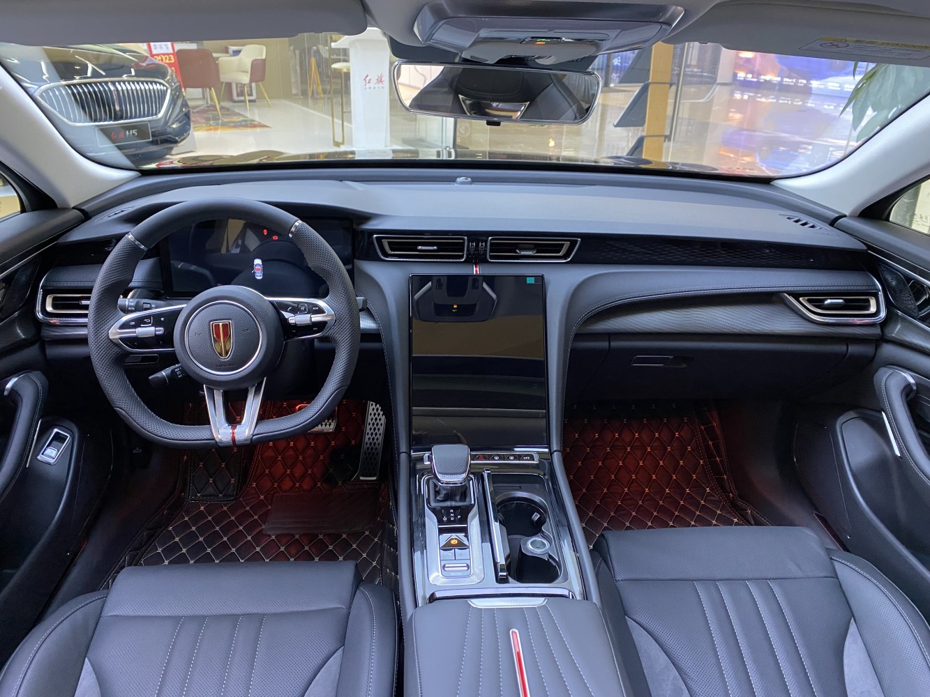 Digital dashboard and touchscreen console with black leather seating and ambient lighting
