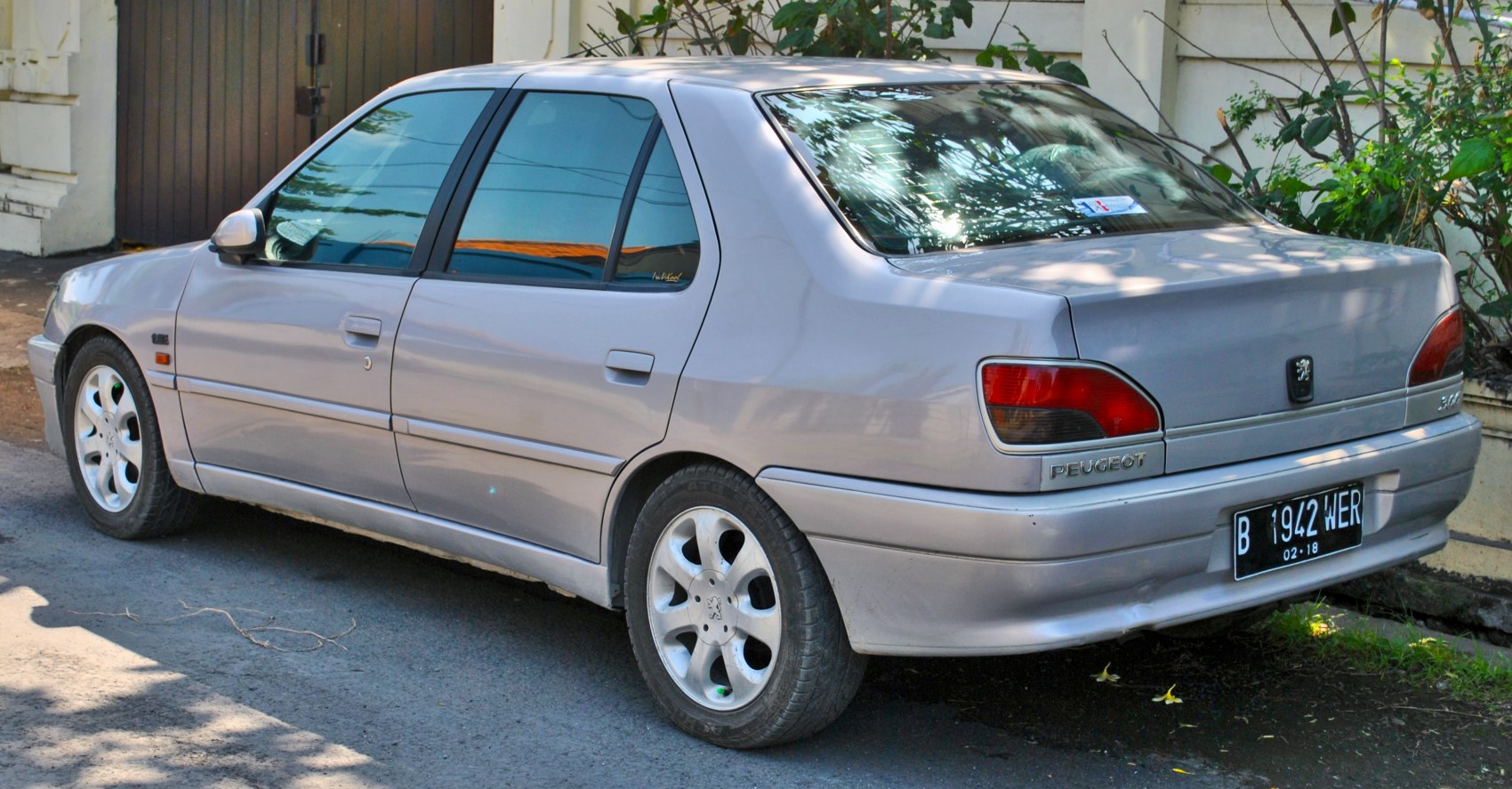 Rear side profile and alloy wheels of a sedan from the mid-90s