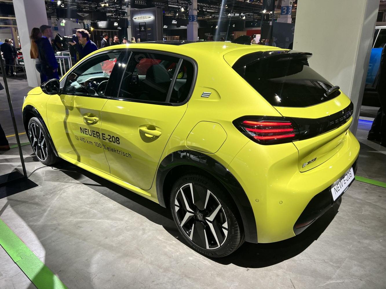 Rear and side view of a yellow electric hatchback with sporty wheels and distinctive lights