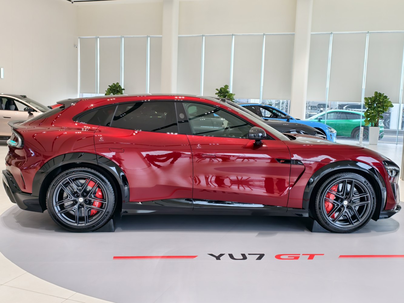 Sleek red coupe SUV side profile with black accents and sporty wheels