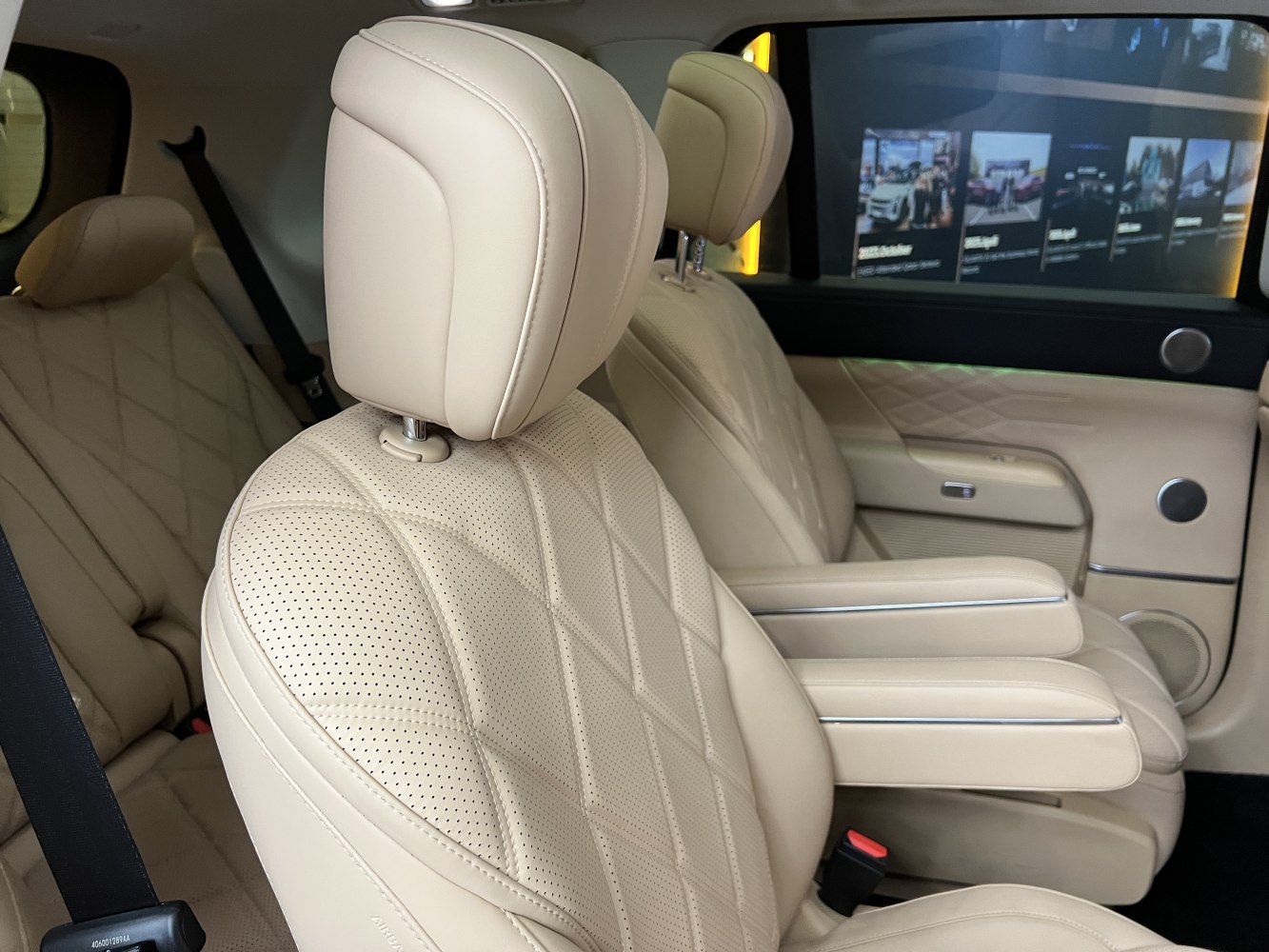 Beige perforated leather seats with armrests in spacious cabin