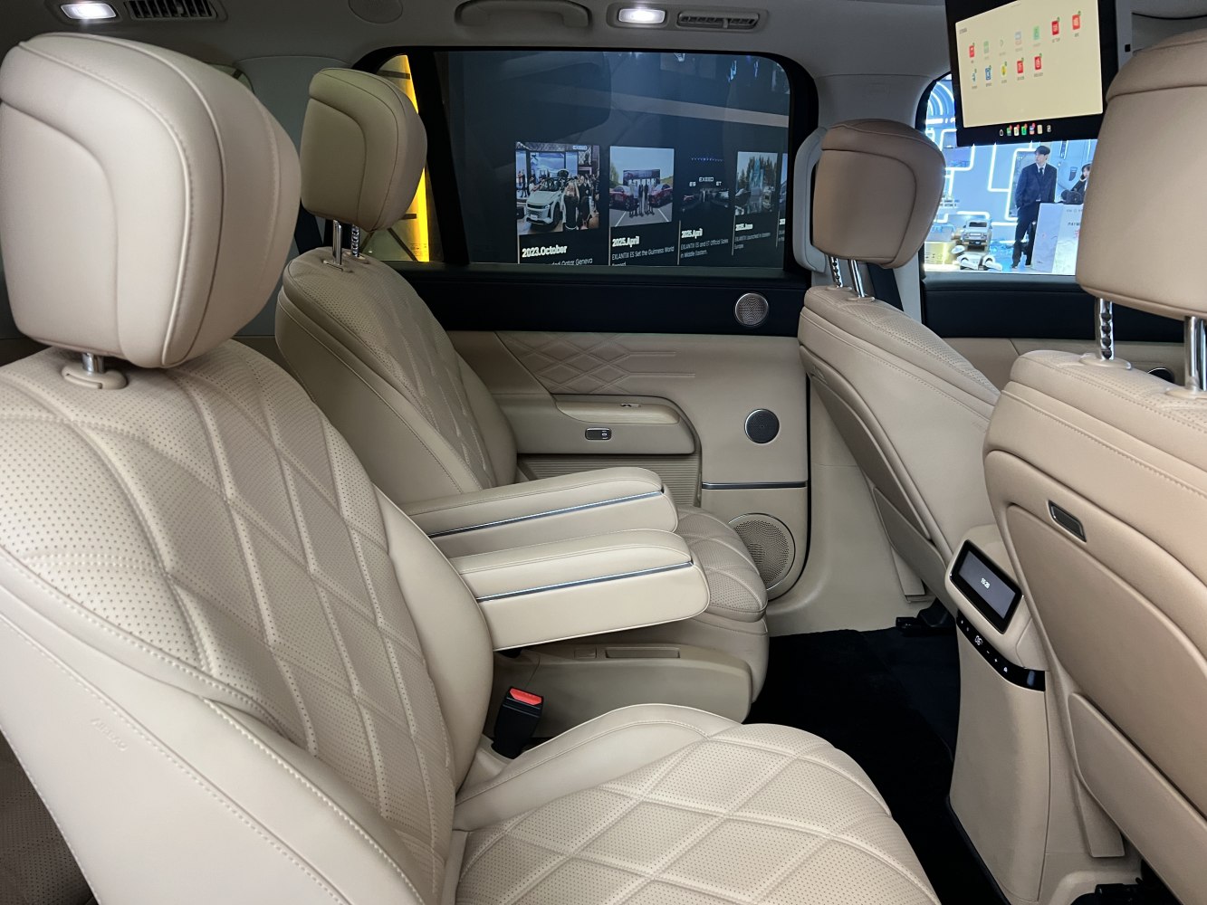 Beige quilted leather rear seats with armrest and entertainment screens