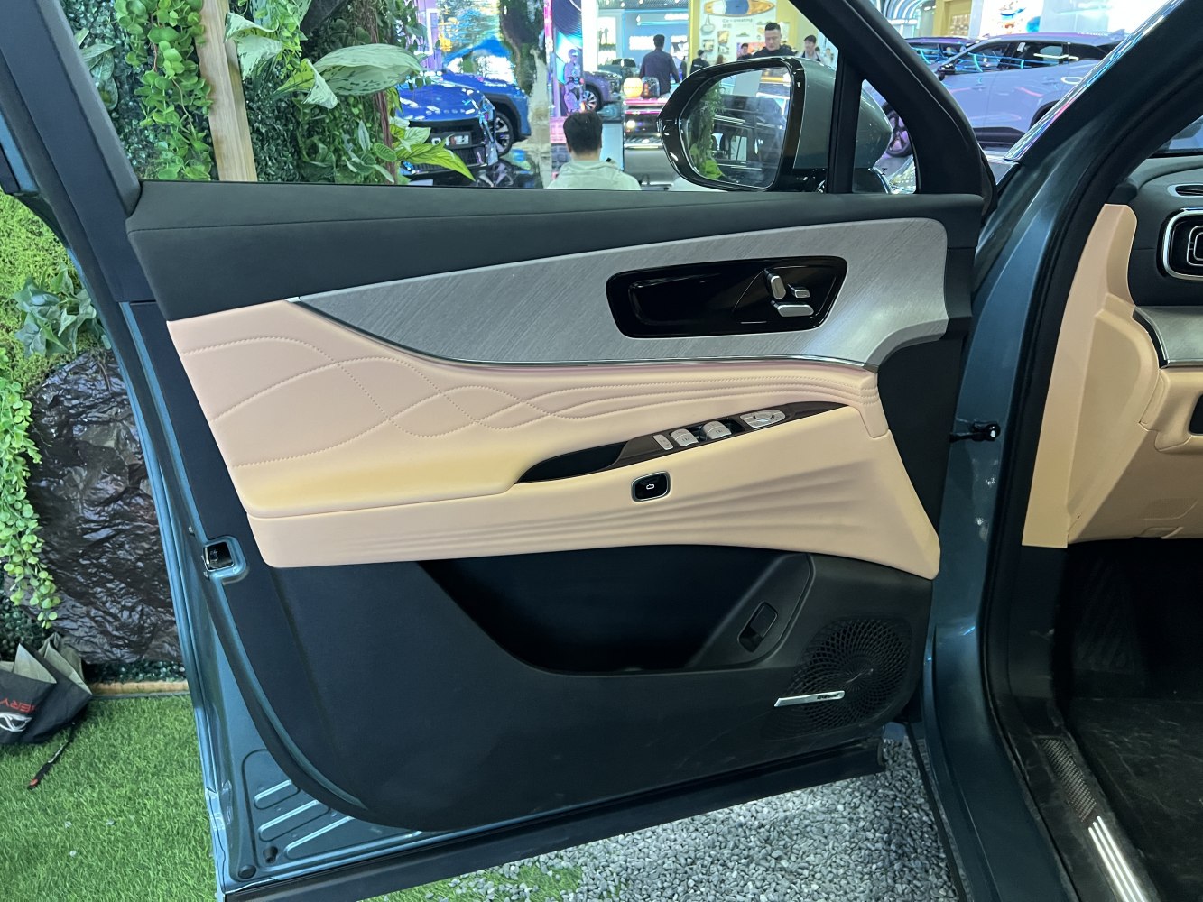 Beige leather door panel with control buttons and speaker grill