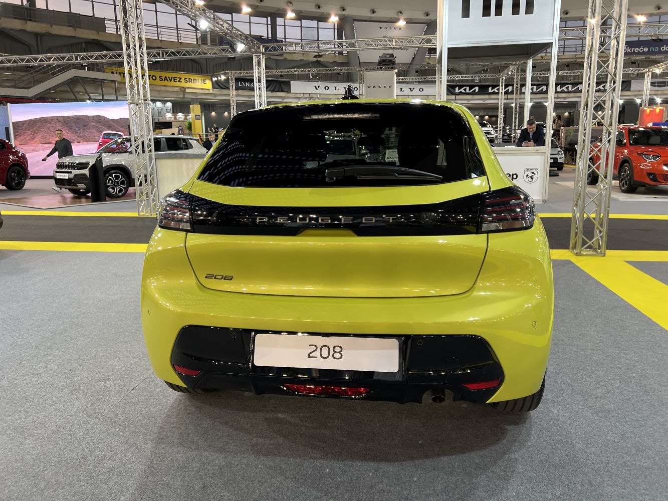 Rear view of yellow compact hatchback with modern taillights and badge