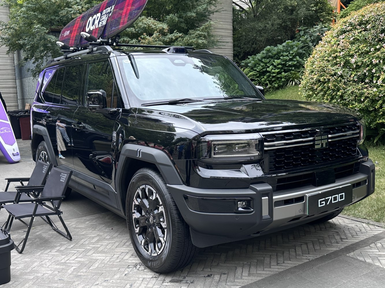 Black SUV with roof rack and surfboard carrier