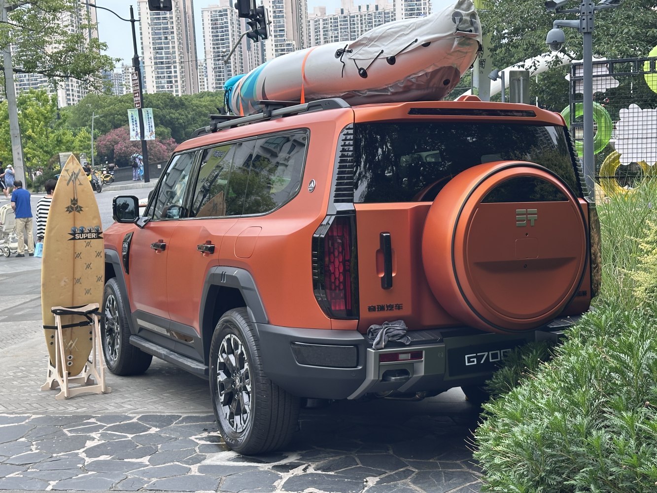 SUV with roof kayak and rear-mounted spare tire.