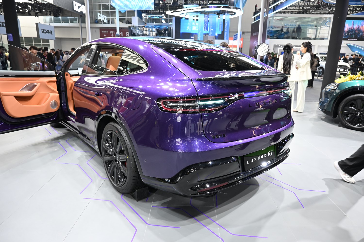 Sleek rear design with full-width taillights and open door showing premium interior