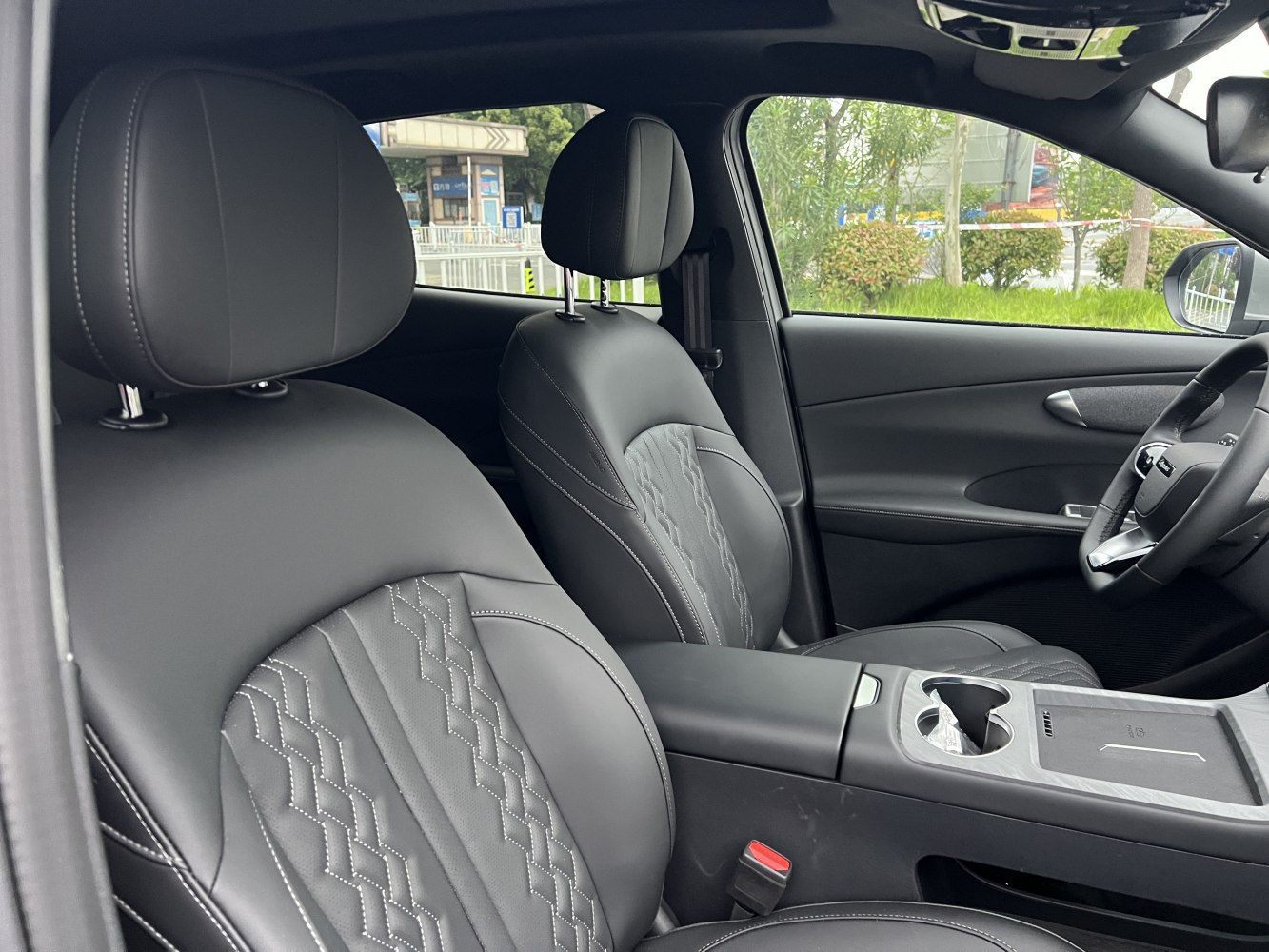 Leather seats with intricate stitching and a modern center console with cup holders.
