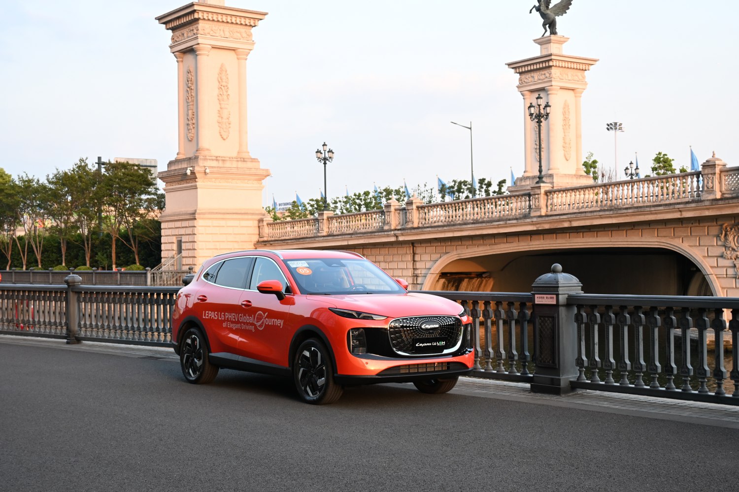 Red SUV with modern grille and sleek headlights near stone bridge