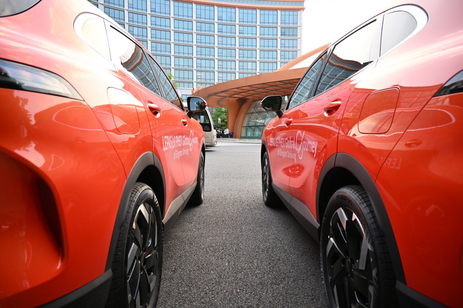 Side profiles of two orange SUVs with black alloy wheels and tinted windows